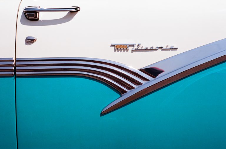 Close-up of the side of a vintage car, featuring a turquoise and white two-tone paint job, chrome trim, and an emblem that reads Crown Victoria—captured as a stunning film photo. | Photo by Millworks Film Photography & Prints